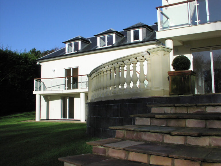 Elegant white luxury home in Cheshire, featuring a sleek modern design, expansive glass windows, and beautifully landscaped surroundings for a perfect blend of style and sophistication